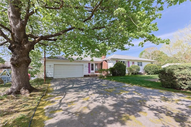 ranch-style home with a chimney, driveway, and an attached garage