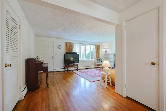 living room featuring wood finished floors, baseboard heating, and a baseboard heating unit
