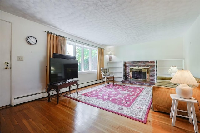 living room with a baseboard radiator, a brick fireplace, and hardwood / wood-style flooring