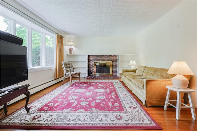 living room featuring a fireplace, a textured ceiling, and wood finished floors