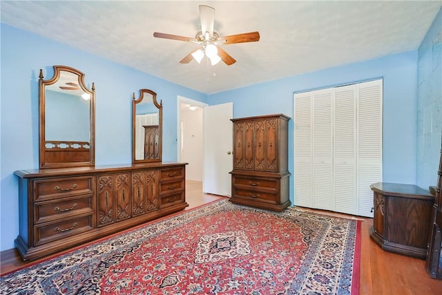 bedroom with a closet, wood finished floors, and ceiling fan