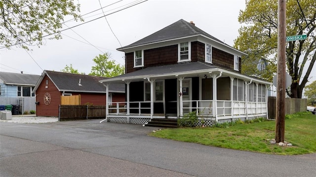 farmhouse-style home with a porch and fence