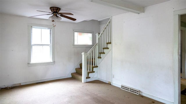 interior space with visible vents, stairway, ceiling fan, beamed ceiling, and baseboards