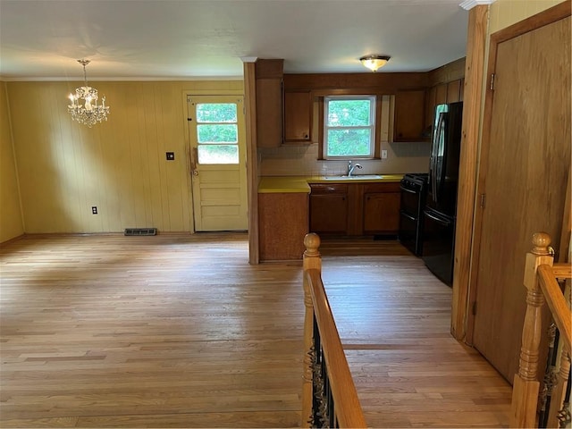 10 Lawnwood Rd, Coventry, RI 02816 - kitchen featuring black appliances, a chandelier, brown cabinets, light countertops, and light wood-style flooring