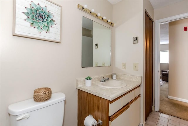 half bathroom featuring vanity, toilet, and tile patterned flooring