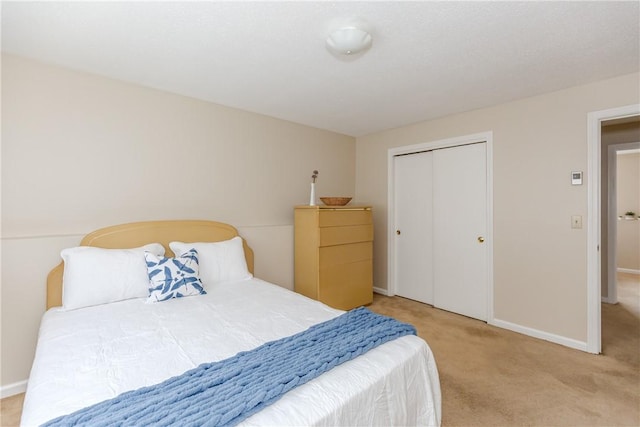 carpeted bedroom with baseboards and a closet