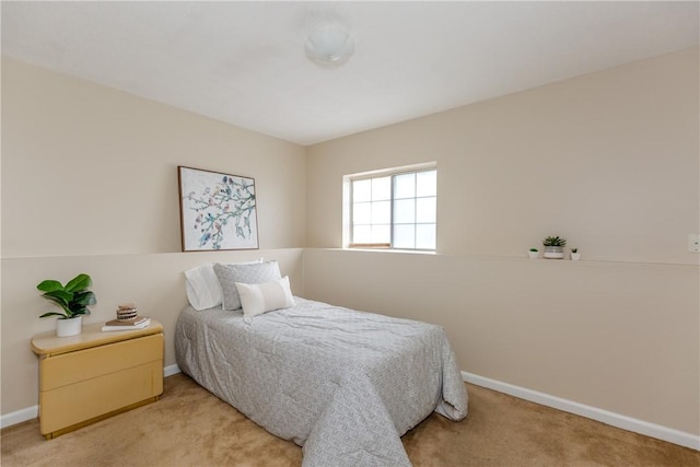 bedroom featuring light colored carpet and baseboards