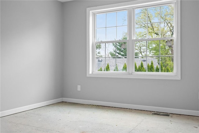 spare room with baseboards, a healthy amount of sunlight, and visible vents