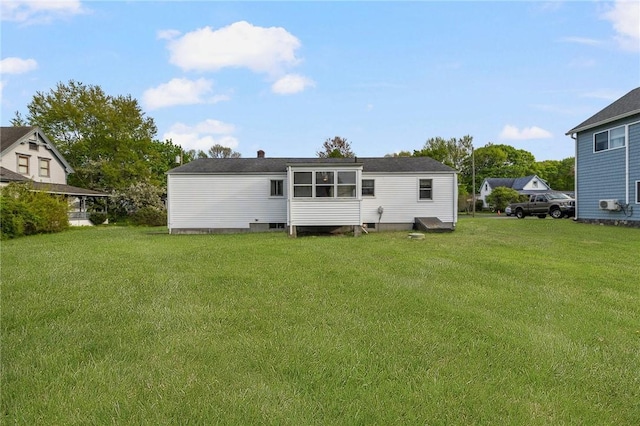 rear view of property with a lawn