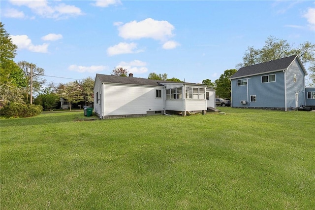 rear view of property with a sunroom and a yard