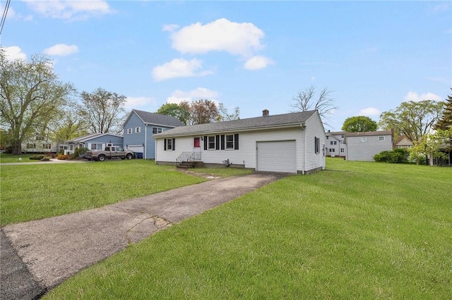 view of front of property with a front yard, driveway, a chimney, and a garage