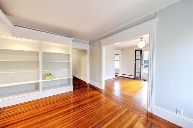 unfurnished room featuring hardwood / wood-style flooring, baseboards, and baseboard heating