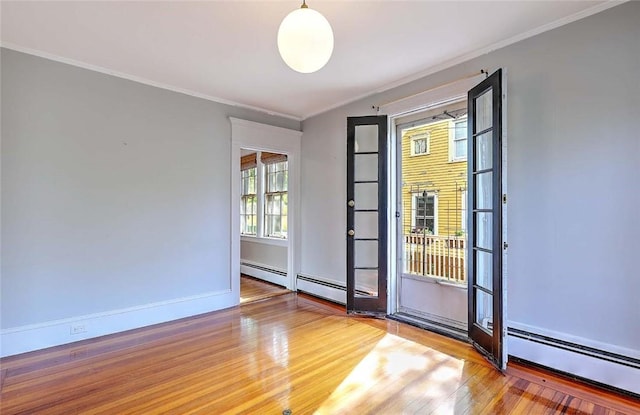 interior space featuring baseboards, baseboard heating, crown molding, and wood finished floors