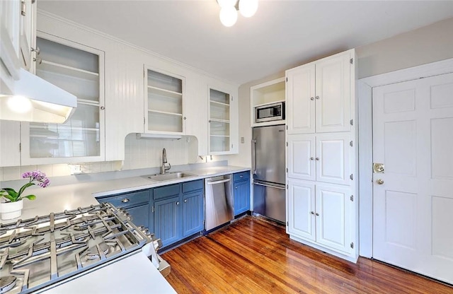 kitchen with a sink, white cabinetry, built in appliances, light countertops, and blue cabinetry