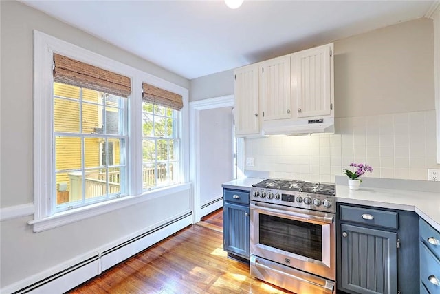 kitchen featuring under cabinet range hood, light countertops, stainless steel gas range oven, and a baseboard heating unit