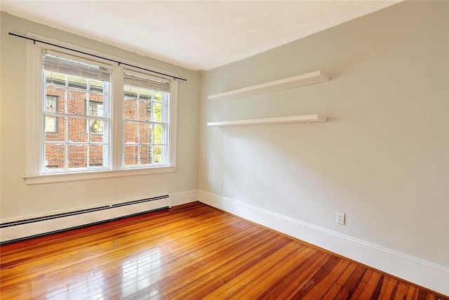 spare room with a baseboard radiator, baseboards, and hardwood / wood-style floors