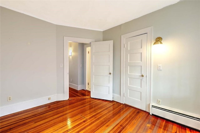 unfurnished bedroom featuring baseboards, a baseboard radiator, and light wood-type flooring