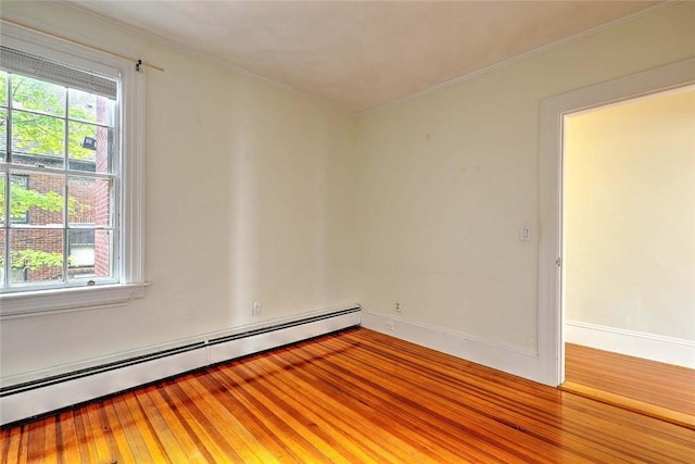 empty room with a healthy amount of sunlight, light wood-style flooring, and baseboard heating