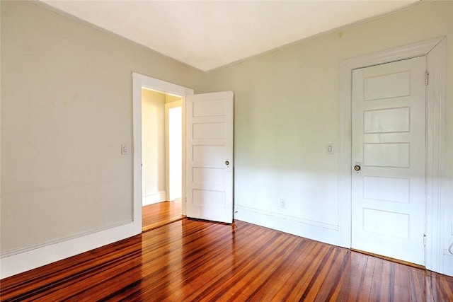 spare room with wood finished floors and baseboards