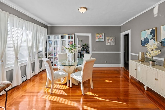 dining room with crown molding and light wood-type flooring