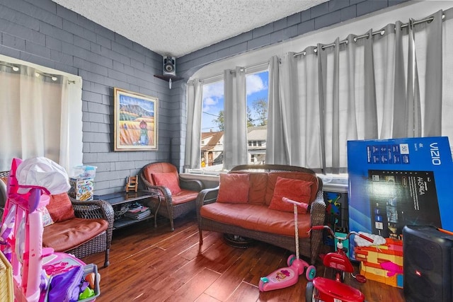 living area with a textured ceiling and wood finished floors