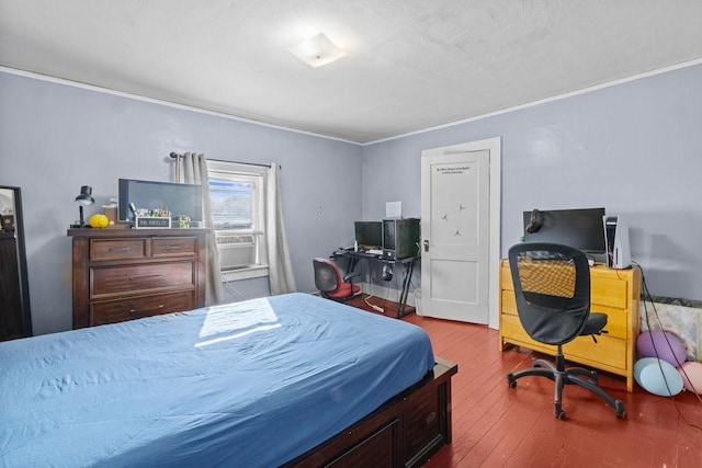 bedroom featuring ornamental molding and wood finished floors