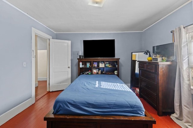 bedroom featuring crown molding, baseboards, and wood finished floors
