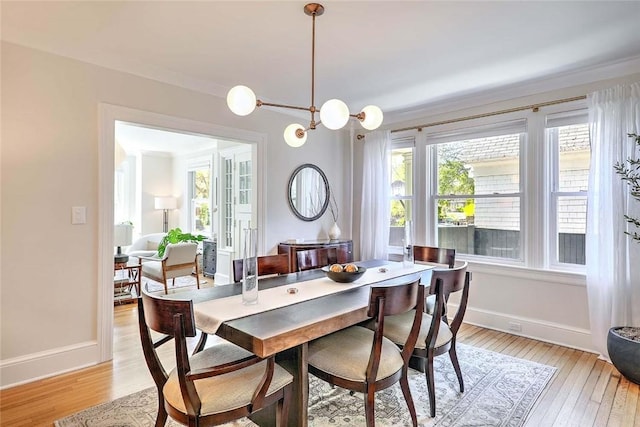 dining area featuring light wood-type flooring and baseboards