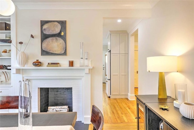 living area featuring light wood-type flooring, recessed lighting, a fireplace, beverage cooler, and baseboards
