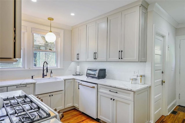 kitchen with light wood finished floors, dishwasher, a toaster, and a sink