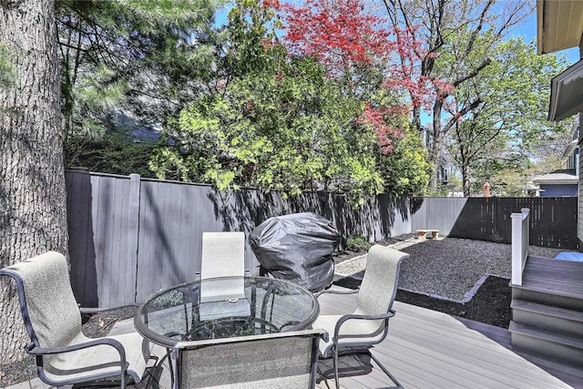 wooden deck with a fenced backyard