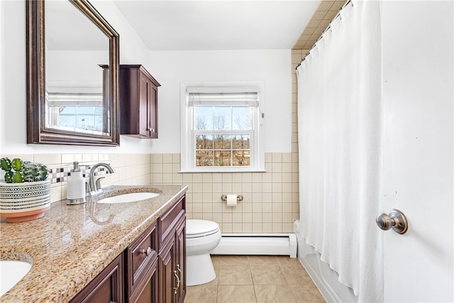 bathroom featuring tile walls, baseboard heating, toilet, a sink, and tile patterned flooring