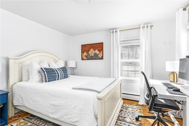 bedroom featuring baseboard heating and light wood-style flooring