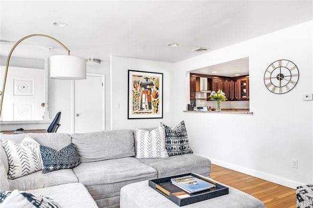 living room featuring light wood finished floors, baseboards, visible vents, and recessed lighting