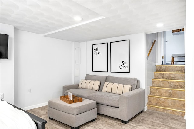 living room featuring recessed lighting, light wood-type flooring, baseboards, and stairs