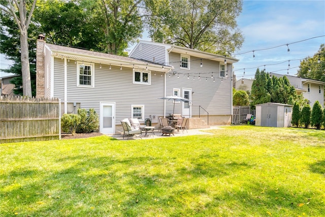 rear view of house with a chimney, a lawn, fence, a patio area, and a storage unit