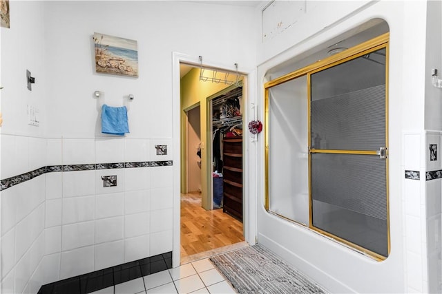 215 Rocky Point Ave, Warwick, RI 02889 - bathroom with tile walls, tile patterned floors, a wainscoted wall, and a walk in closet