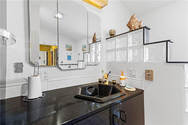 215 Rocky Point Ave, Warwick, RI 02889 - kitchen with dark stone countertops, a sink, and vaulted ceiling