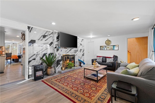 215 Rocky Point Ave, Warwick, RI 02889 - living room featuring a premium fireplace, light wood finished floors, heating unit, and recessed lighting