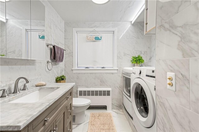215 Rocky Point Ave, Warwick, RI 02889 - bathroom featuring toilet, tile walls, independent washer and dryer, vanity, and radiator heating unit