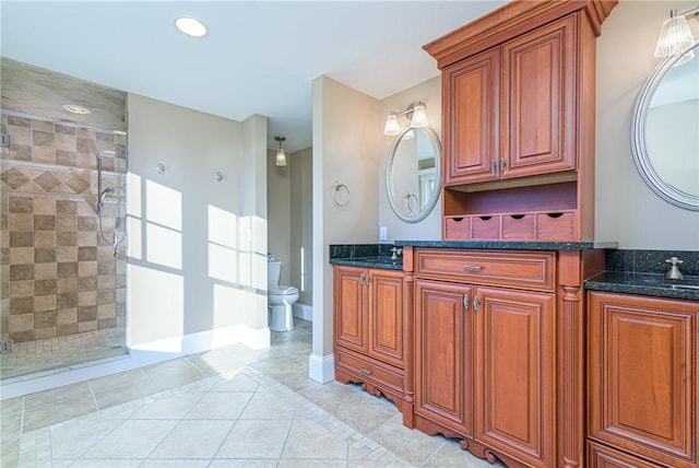 bathroom with tile patterned flooring, toilet, a shower stall, and vanity
