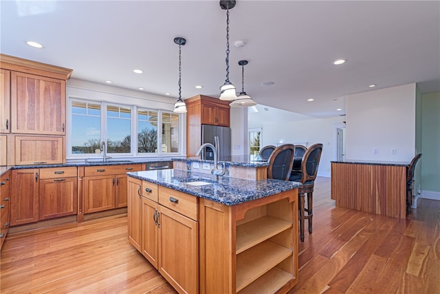 kitchen with a sink, light wood-style floors, and appliances with stainless steel finishes