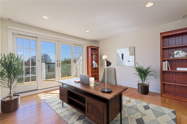 home office with baseboards, recessed lighting, french doors, and light wood-type flooring