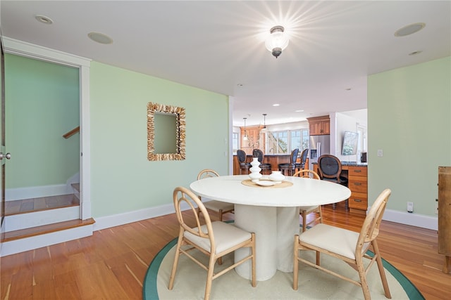 dining space featuring recessed lighting, light wood-style flooring, baseboards, and stairs