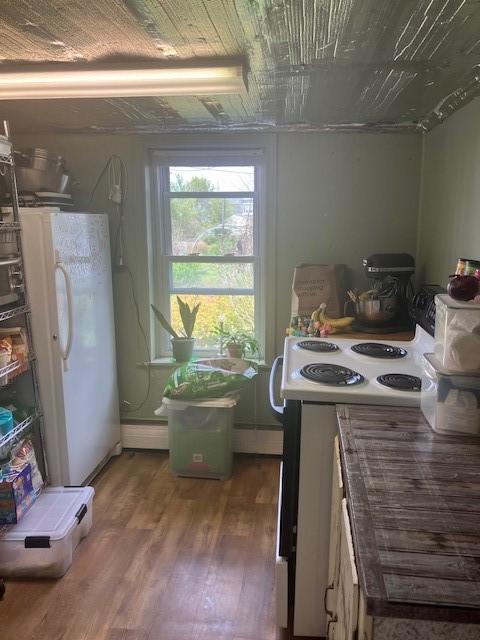 kitchen featuring wood finished floors, tile counters, and white appliances