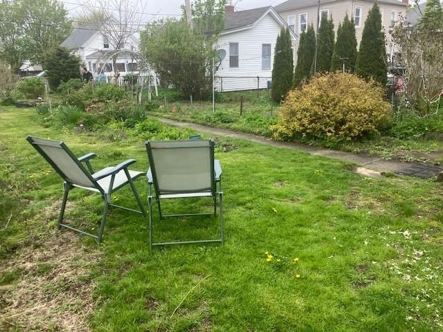 view of property's community with fence and a lawn