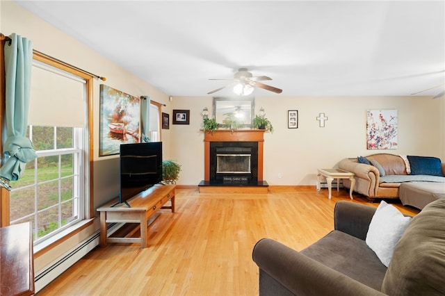 51 Mill Rd, Foster, RI 02825 - living room with light wood-style flooring, a glass covered fireplace, baseboard heating, a ceiling fan, and baseboards