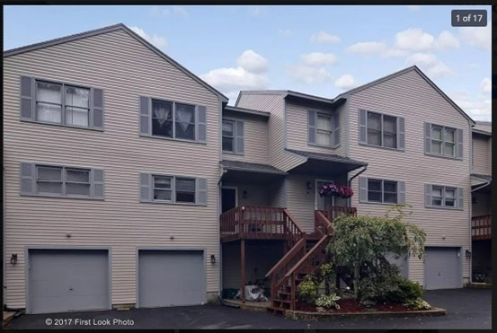 townhome / multi-family property featuring driveway, stairway, and a garage