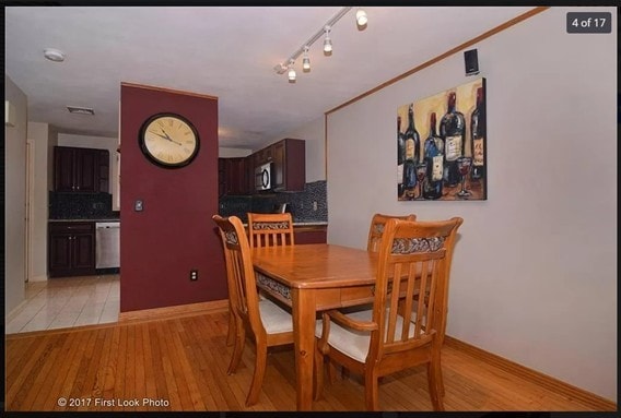 dining area with baseboards, light wood-style flooring, and track lighting