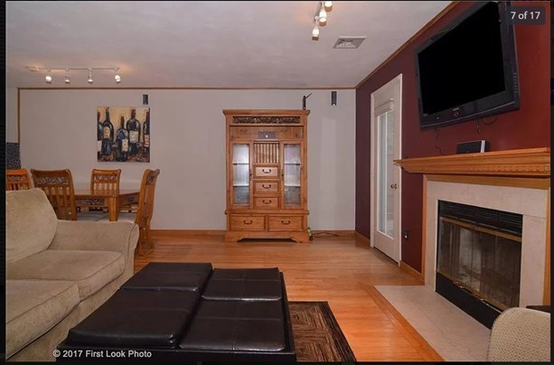 living room featuring wood finished floors, visible vents, track lighting, baseboards, and a fireplace with flush hearth